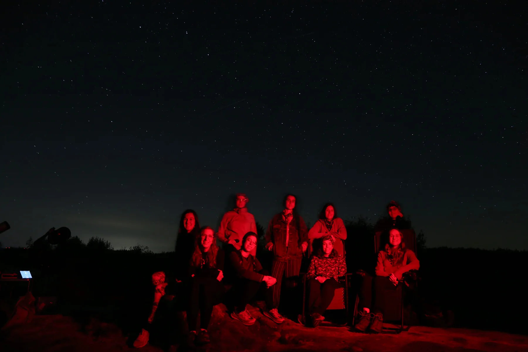Le groupe de la balade, assis sous le ciel nocturne