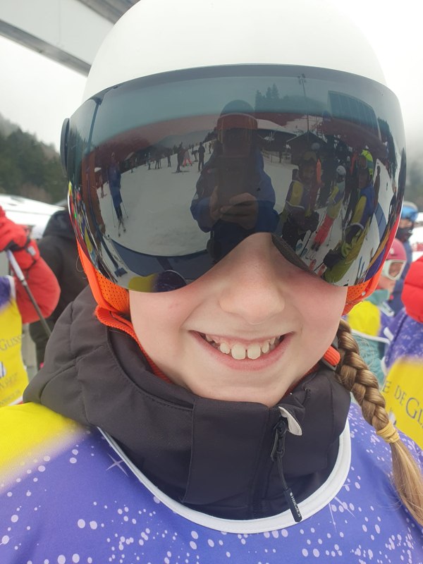 Une élève sourit, le masque reflète les pistes